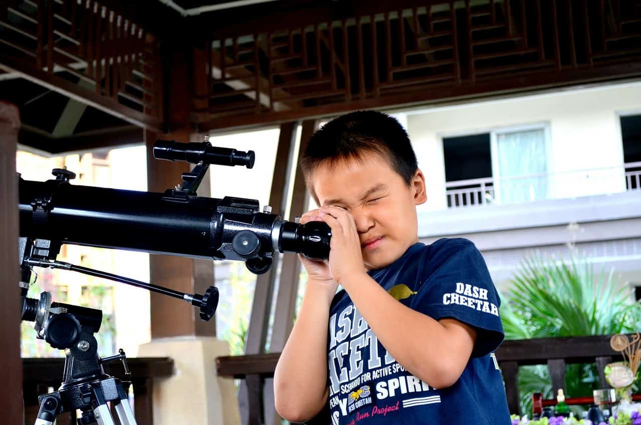 child using a telescope