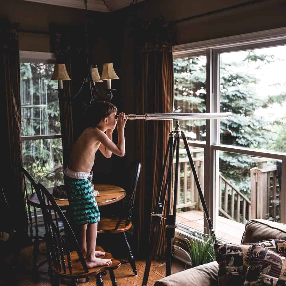 kid using a heavy telescope instead of a monocular