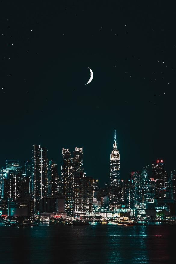 The moon shines brighter than the city lights.