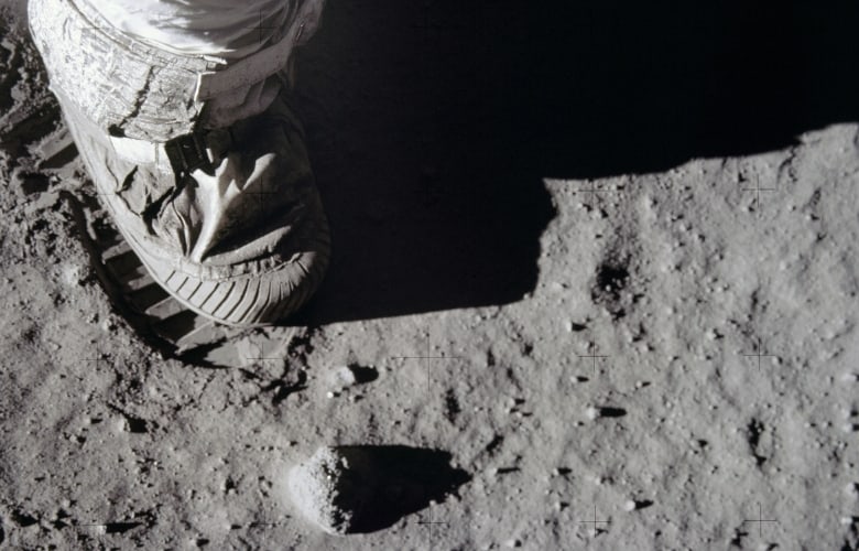 Close-up view of astronauts foot and footprint in lunar soil after uSA landed on moon