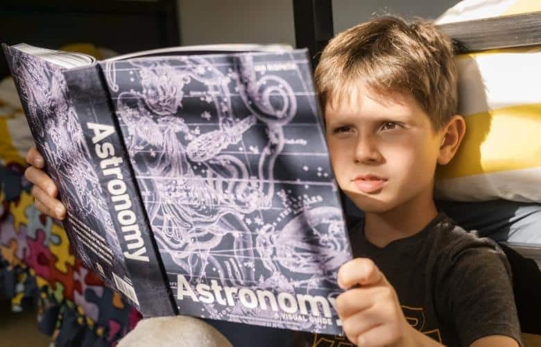 Young student reading an astronomy book
