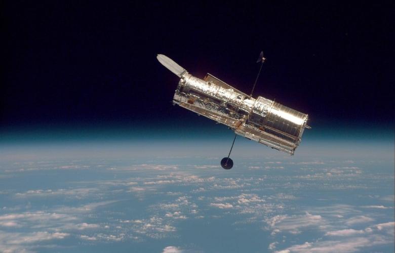 In this image, the Hubble Space Telescope is hovering at the Earth-space boundary.